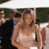 a woman in a pink dress is standing in a crowd