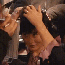 a close up of a person 's head with their hands on it