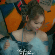 a woman in a blue dress with verified beauty ms written on the bottom right