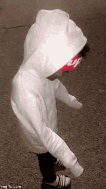 a little girl wearing a white hoodie and a red headband that says supreme