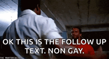 a man in a white shirt is talking to another man in a red shirt in a video .