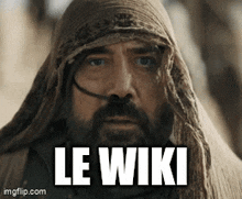 a man with a beard is wearing a scarf around his head and the words le wiki are on his face