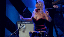 a woman singing in front of an amplifier that says diamond