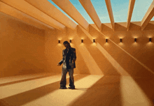 a man in a suit is standing in a room with a skylight above him