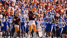 a football player wearing a number 55 jersey runs with the ball
