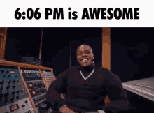 a man in a black shirt is sitting in front of a bunch of electronics and says 6:06 pm is awesome ..