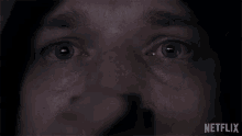 a close up of a person 's blue eyes with a netflix logo behind them