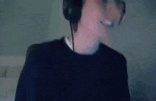 a man wearing headphones and a headset is smiling and looking at the camera .