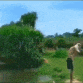 a blurry picture of a man in a field with trees in the background