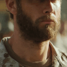 a man with a beard is wearing a camouflage uniform