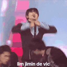 a man is singing into a microphone with the words lim jimin de vic above him