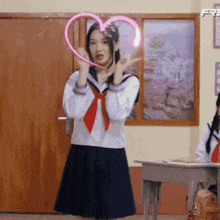 a girl in a school uniform holds a pink heart in her hands