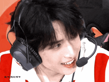 a close up of a person wearing headphones and a microphone with chinese writing on the bottom