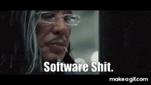 a man wearing glasses and a suit is talking to another man .