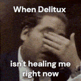 a man in a suit is covering his face with his hand and the words when delicux isn 't healing me