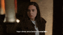 a woman in a dark room with the words hayir olmaz anca beraber kanca bere