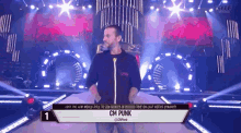 a man is standing on a stage with a sign that says cm punk on it .