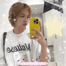 a girl is taking a picture of herself in a mirror wearing a sweatshirt that says bibi y seongmin