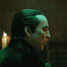 a close up of a man 's face with a green light shining on it