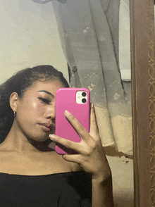 a woman is taking a selfie with her pink phone