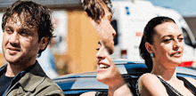 a man and two women are sitting in a car