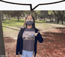 a girl wearing a mask giving a thumbs up in front of a speech bubble