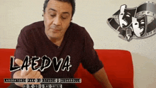 a man sitting on a red couch with the words laedva written on the bottom