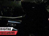 a man in a floral shirt stands in front of a digital exclusive banner