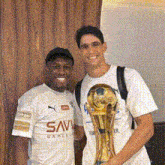 two men posing for a picture with one wearing a shirt that says savi