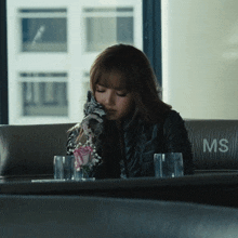 a woman sits on a couch with the letter ms on the back