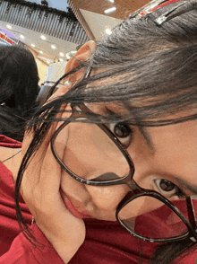 a close up of a woman wearing glasses making a face