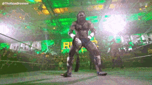 a wrestler is standing in the middle of a wrestling ring holding a championship belt .