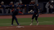 a baseball player runs to first base while a umpire looks on