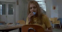 a woman sitting in a chair smoking a cigarette and holding a can of soda .