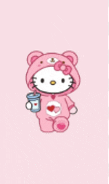 hello kitty is wearing a teddy bear costume and holding a cup of soda .