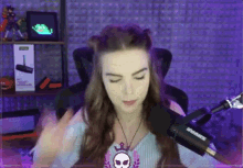 a woman sitting in front of a shure microphone with her eyes closed