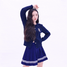a girl wearing a blue sweater and a blue skirt has the letter p on her sweater