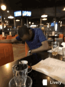 a man is sitting at a table in a restaurant with the word lively on the bottom