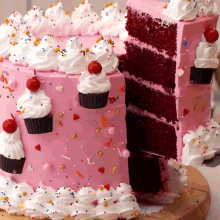 a pink cake with white frosting and sprinkles has a slice taken out of it