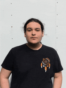 a man in a black shirt with a dream catcher on it