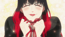 a girl with black and red hair is smiling and holding a red ribbon around her neck