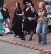 a woman in a witch costume is dancing with a group of people
