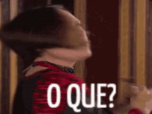 a woman is making a funny face with the words o que written on the screen .