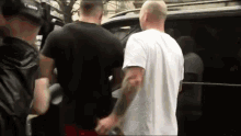 a group of men are standing next to each other in a car .