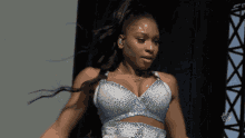 a woman wearing a blue bra with rhinestones and a necklace that says ' i love you '