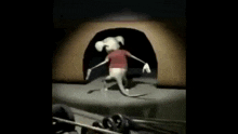 a cartoon mouse is running out of a hole in a wall .