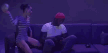 a woman is sitting on a man 's lap on a couch in a dark room .