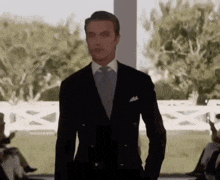 a man in a suit and tie is standing in front of a crowd of people .