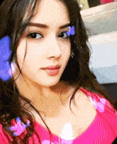 a close up of a woman 's face with a pink shirt on
