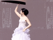 a woman in a purple dress is holding a piece of paper